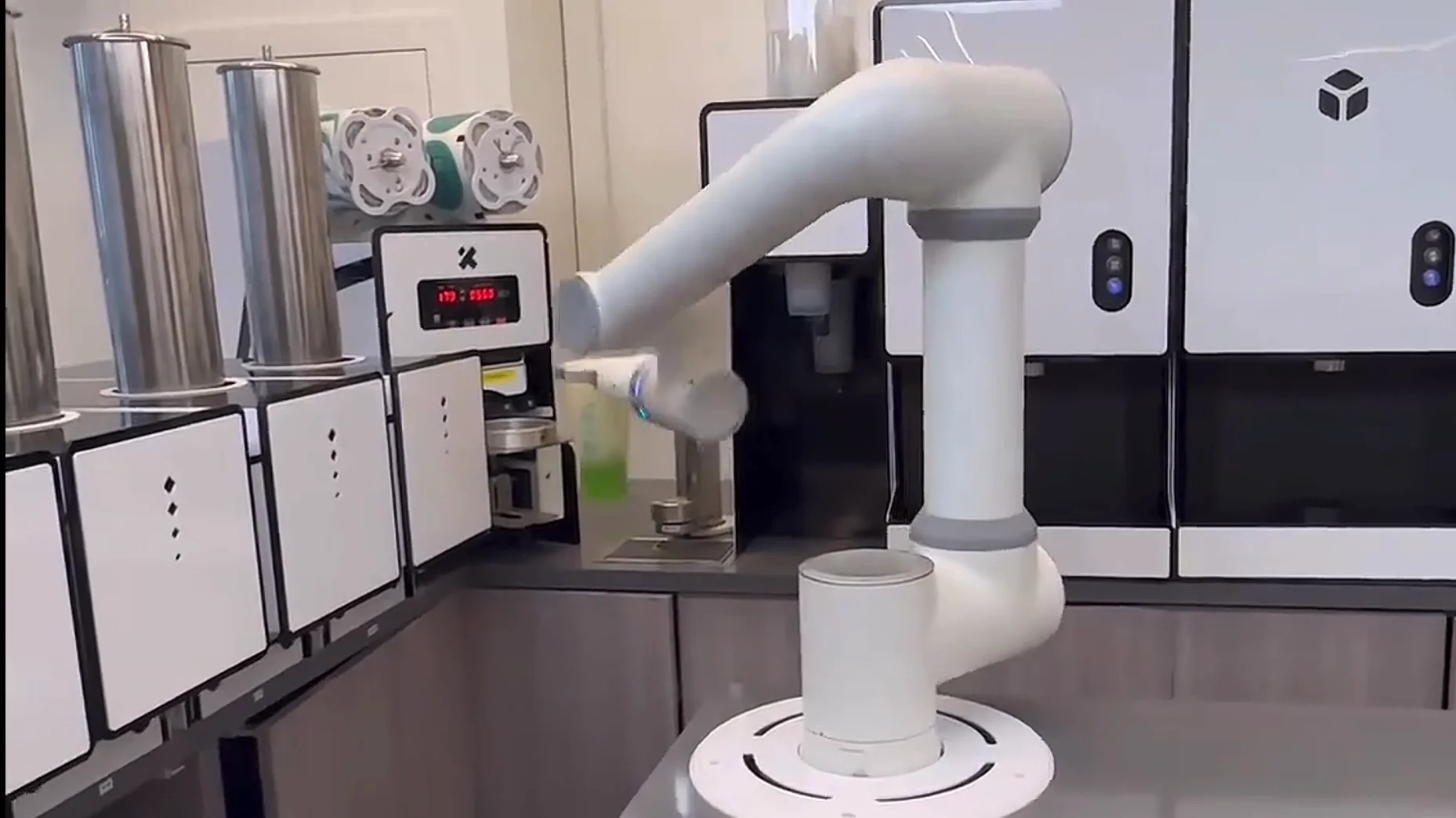 Retail and service scene: collaborative robotic arm pouring and prepping at a front-house station.